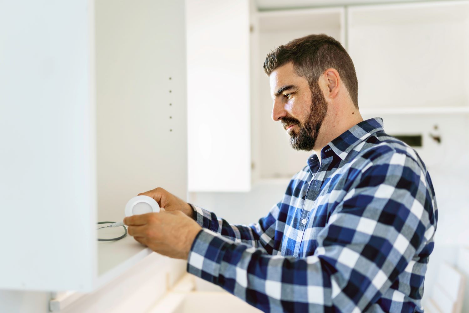 Electricien qui installe un luminaire