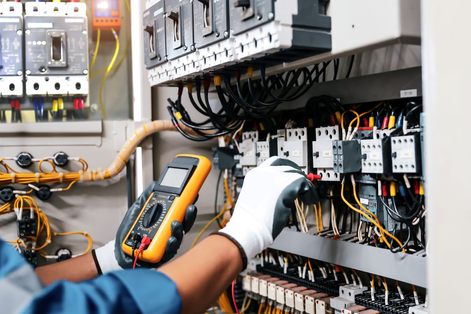 Electricien qui s'occupe d'un tableau électrique